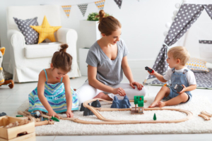 mum building wooden railway with children