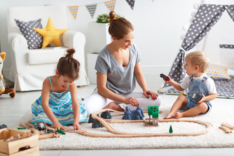 mum building wooden railway with children